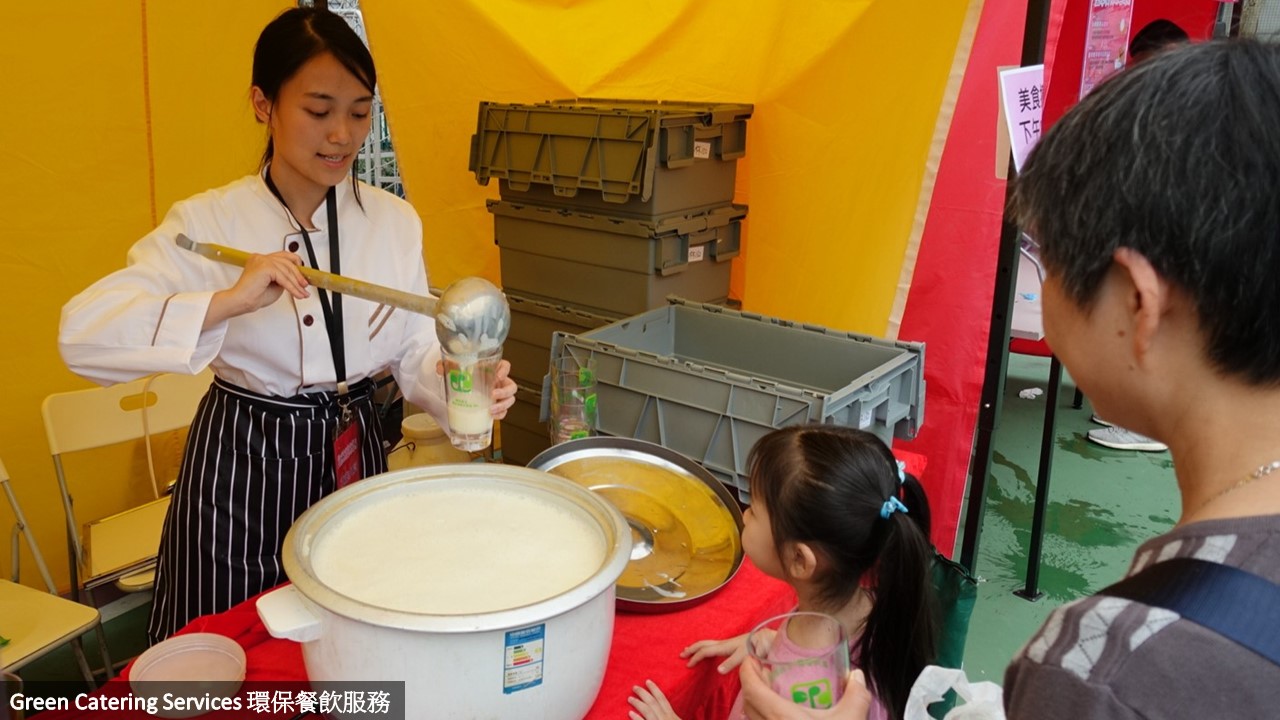 美食攤檔負責人將飲料倒入可重用杯給活動參加者飲用